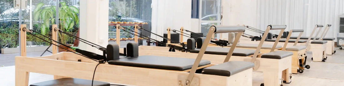 Rangée de machines Reformer Pilates en bois de chêne clair, studio professionnel lumineux