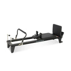 Reformer Pilates aluminium studio pro noir vue de trois quarts, avec repose-pieds et chariot coulissant - Pilates At Home