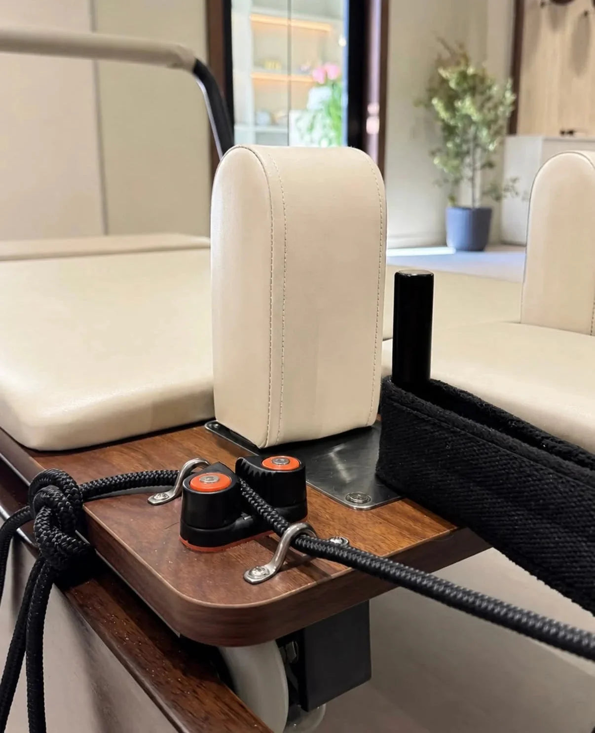 Détail reformer Pilates haut de gamme en bois de chêne avec système de corde réglable