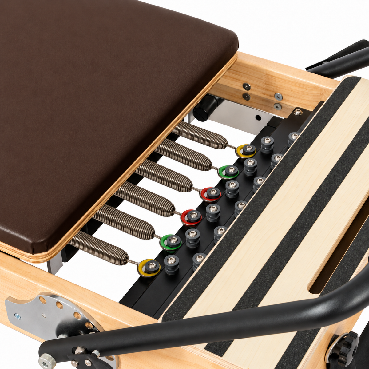 Détail des ressorts et du chariot marron chocolat du Reformer Pilates en bois clair