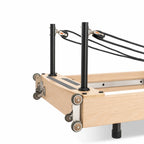 Détail système poulies et cordes du reformer Pilates pliable en bois clair avec montants noirs - Pilates At Home