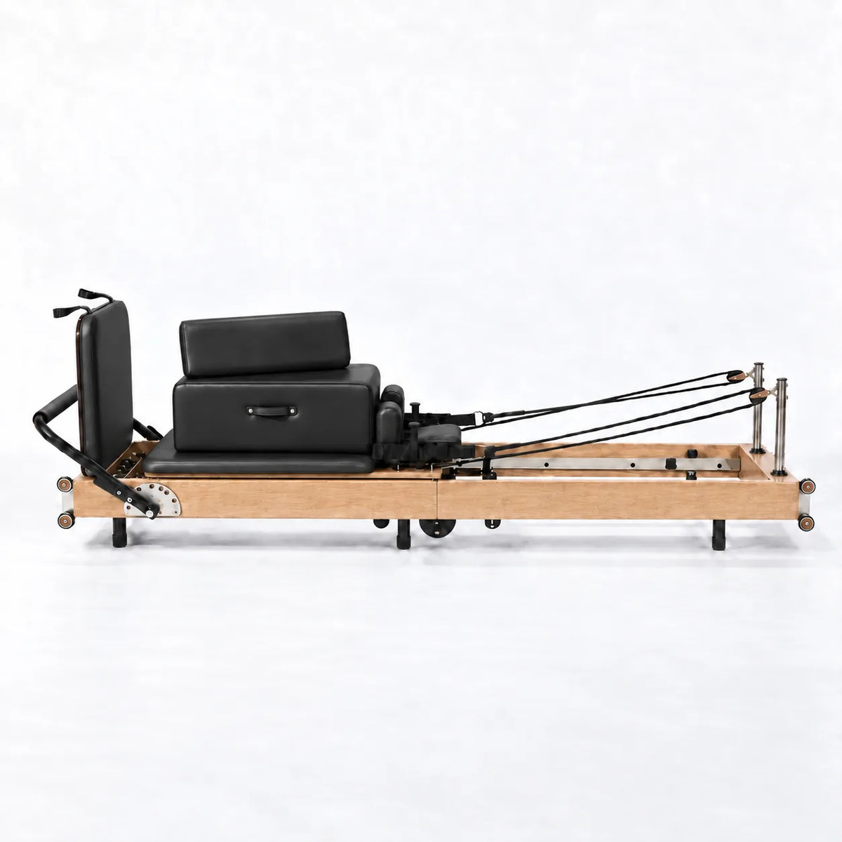 Machine reformer Pilates cadre bois clair avec siège et dossier noir réglables, vue de profil - Pilates At Home