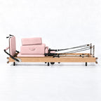Machine reformer Pilates pliable cadre bois clair revêtement rose poudré avec cordes, vue de profil - Pilates At Home