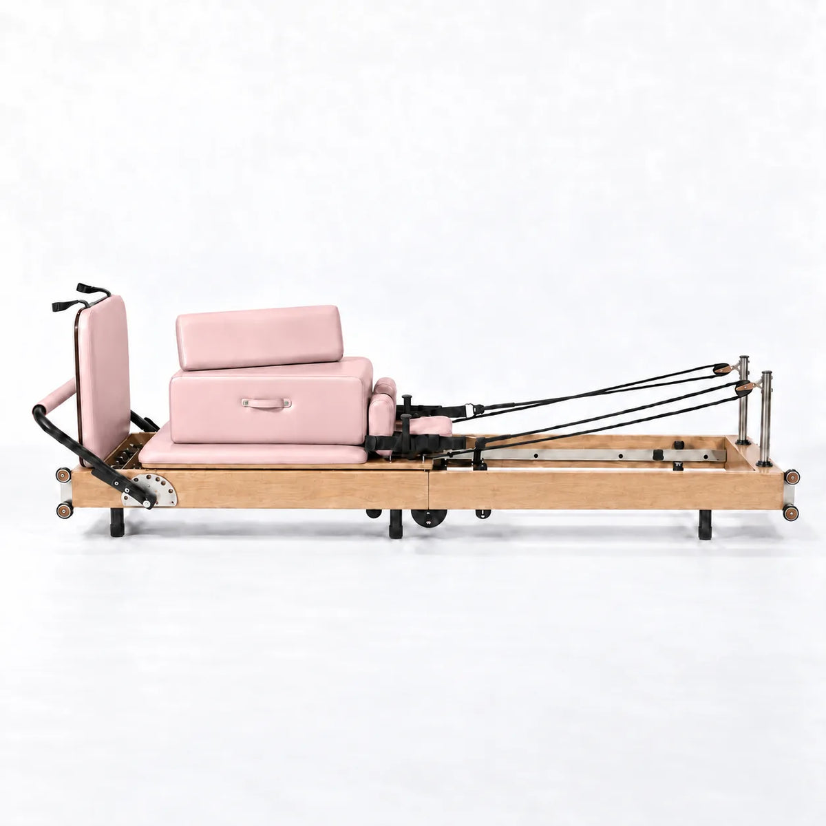 Machine reformer Pilates pliable cadre bois clair revêtement rose poudré avec cordes, vue de profil - Pilates At Home