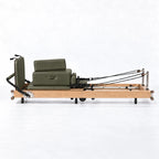 Machine reformer Pilates cadre bois clair avec sellerie vert kaki et cordes de résistance, vue de profil - Pilates At Home