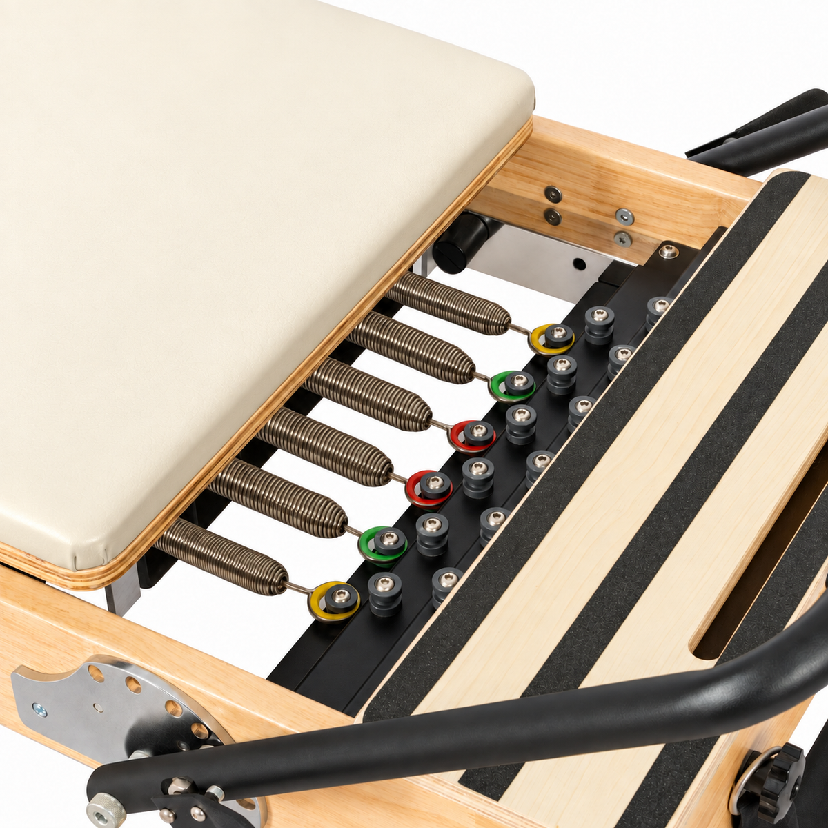 Détail des ressorts et du chariot crème du Reformer Pilates en bois clair