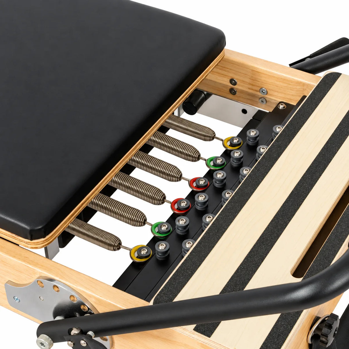 Système de ressorts colorés réglables d'un reformer Pilates studio en bois naturel - Pilates At Home