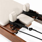 Gros plan sur le chariot crème et les appuis d’épaules du Reformer Pilates