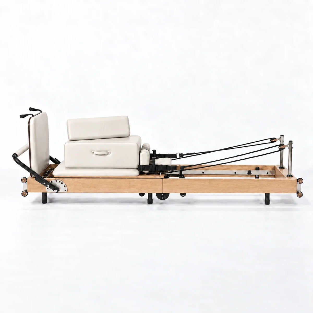 Machine reformer Pilates pliable cadre bois clair assise blanche avec sangles et ressorts, vue de profil - Pilates At Home