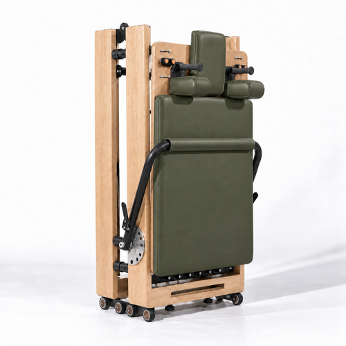 Reformer Pilates pliable en bois clair et revêtement kaki, replié à la verticale