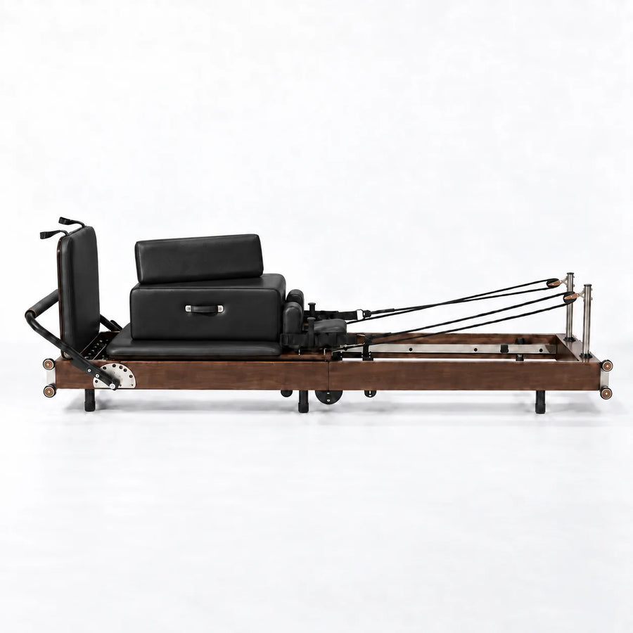 Reformer Pilates At Home en bois foncé avec carriage noir et sangles de résistance