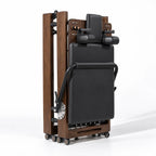 Reformer Pilates pliable Signature replié en position verticale, cadre bois chêne et finition noire - Pilates At Home
