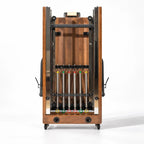 Vue de face du reformer Pilates Signature pliable en bois chêne avec ressorts colorés visibles - Pilates At Home