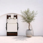 Reformer Pilates pliable Signature replié debout, cadre bois foncé et revêtement blanc crème, vue de face - Pilates At Home