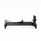 Reformer Pilates Studio Signature en aluminium noir avec cadre bois, vue de profil - Pilates At Home