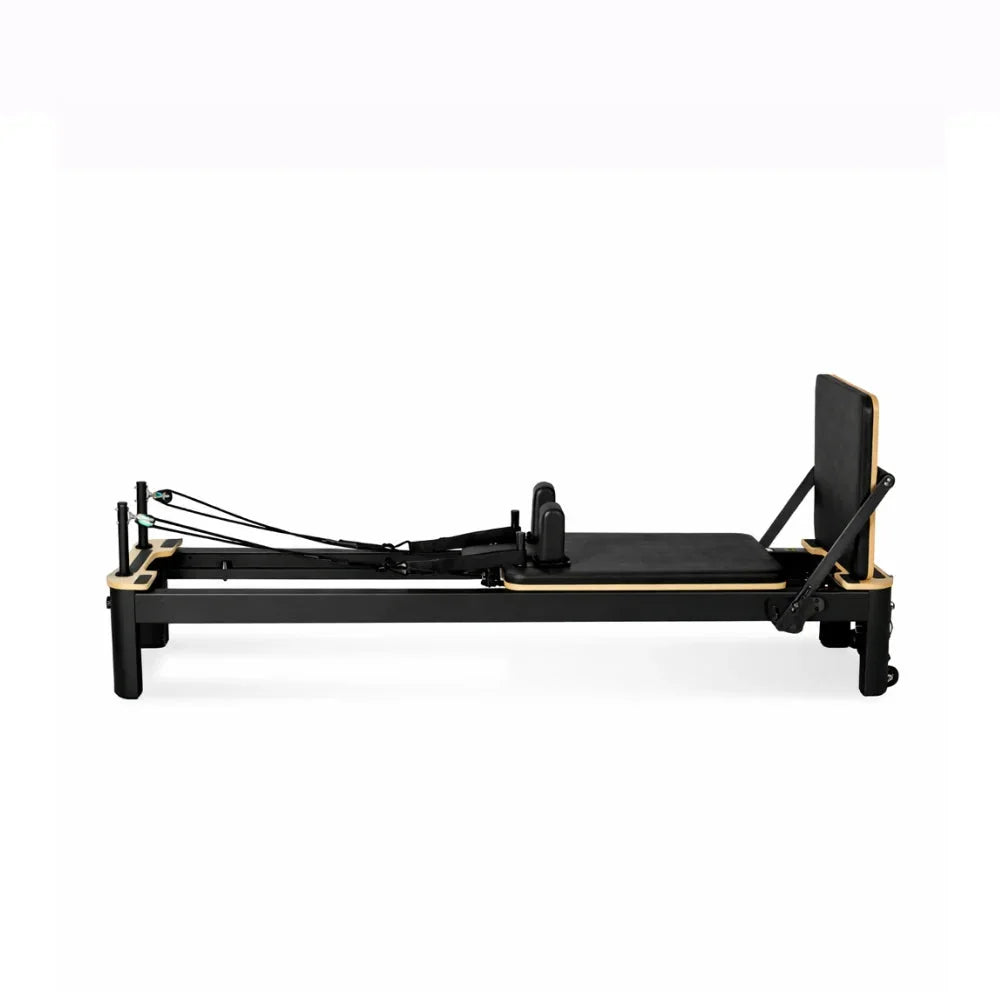 Reformer Pilates Studio Signature en aluminium noir avec cadre bois, vue de profil - Pilates At Home