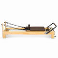 Reformer Pilates Studio en bois clair avec revêtement marron chocolat, vu de profil