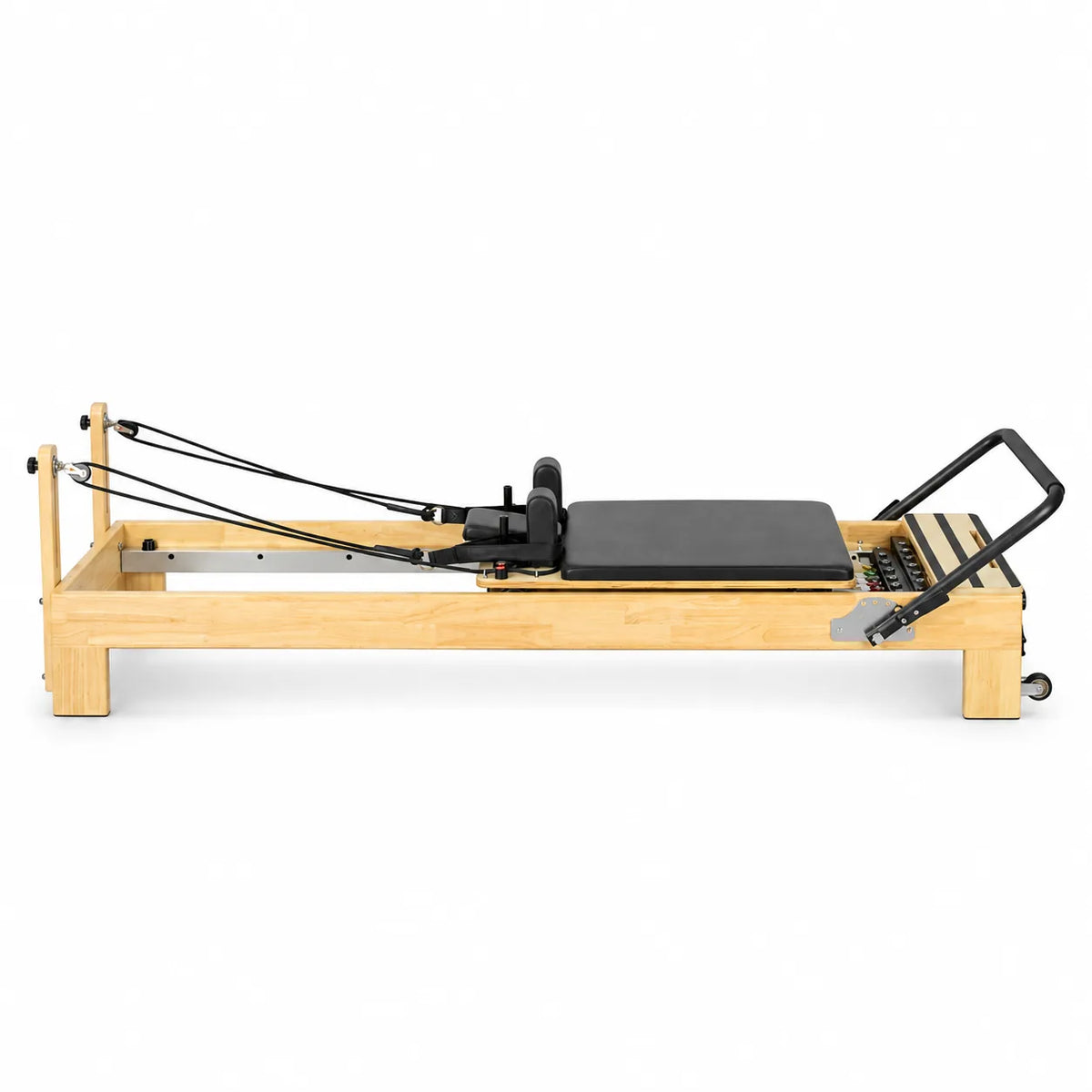 Reformer Pilates studio cadre bois clair avec carette noire et sangles, vue de profil - Pilates At Home