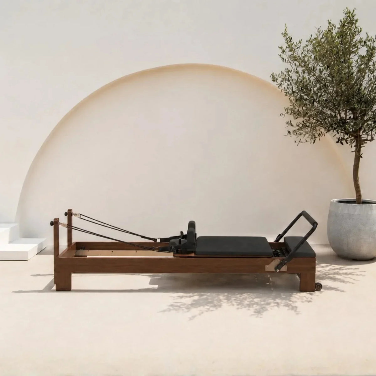 Reformer Pilates Studio Signature cadre bois foncé carrossage noir, vue de profil - Pilates At Home