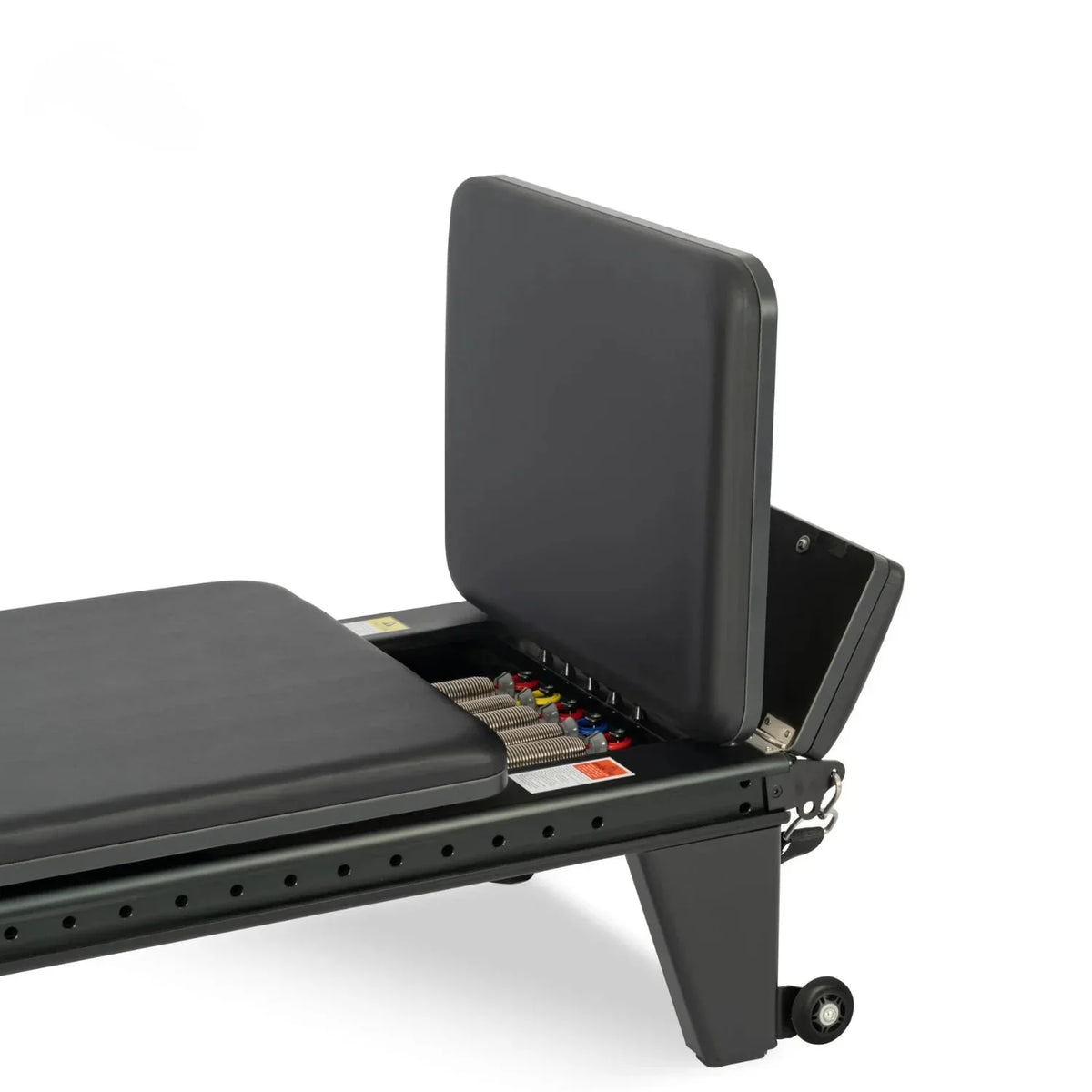 Compartiment de stockage ouvert du Reformer Pilates Studio Pro avec ressorts colorés visibles - Pilates At Home