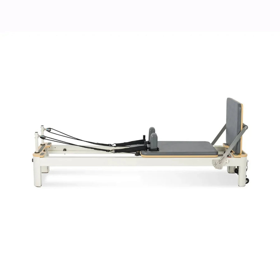 Reformer Pilates Studio Signature en aluminium blanc avec carrosserie grise et footbar réglable, vue de profil - Pilates At Home