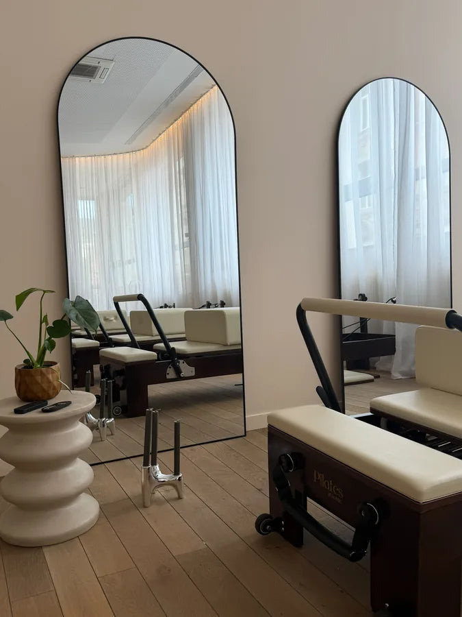 Reformers et grands miroirs arrondis du studio Giolia Pilates